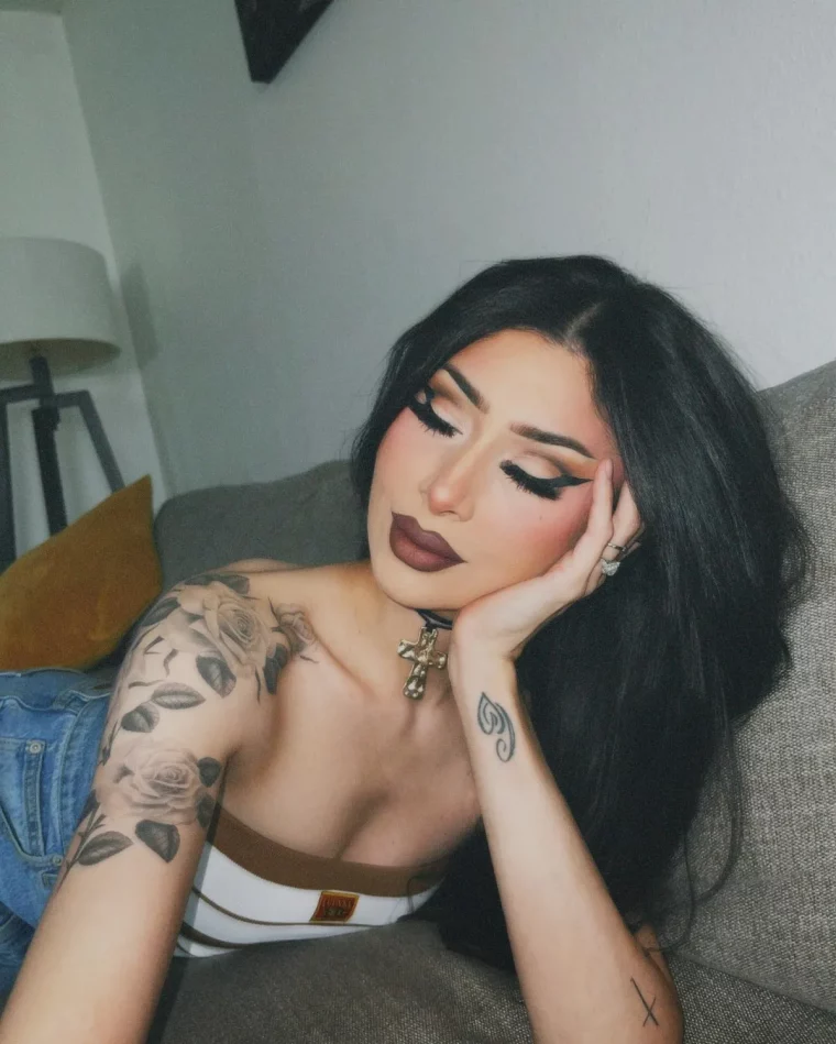 junge frau mit schultertattoo mit rosen und kleines tattoo am handgelenk