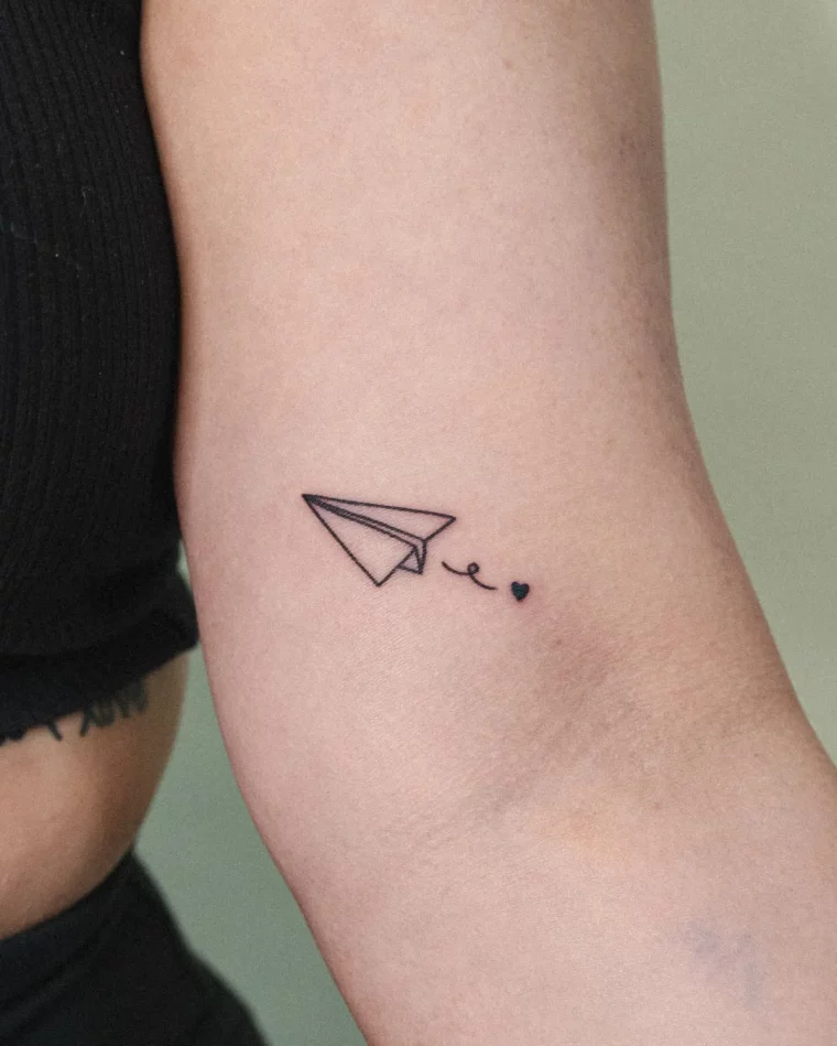kleines tattoo am oberarm papierflieger