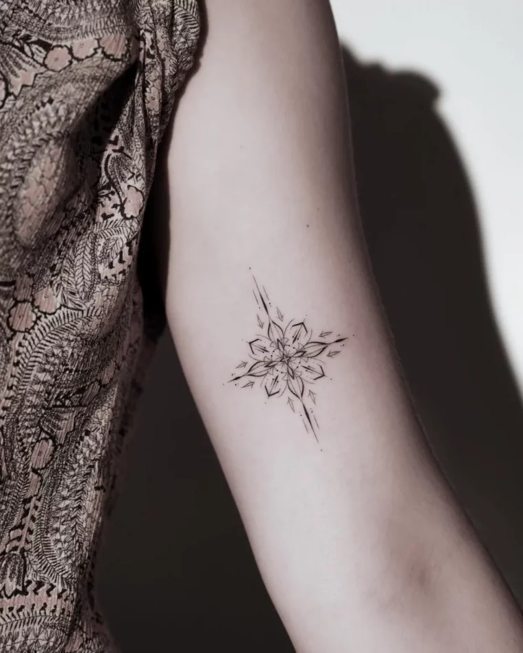 kreuz stern tattoo am oberarm einer frau