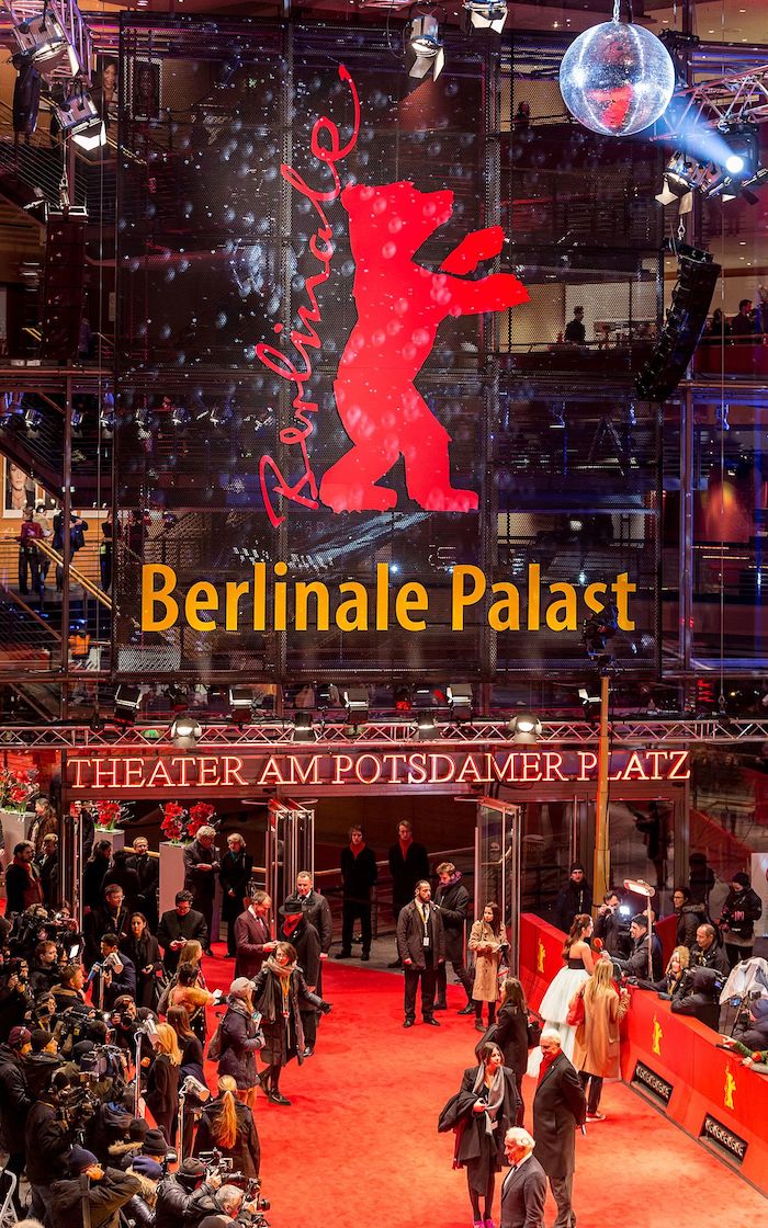 theater am potsdamer palast und viele menschen und rotter teppich, logo bon berlinale mit einem roten großen bär