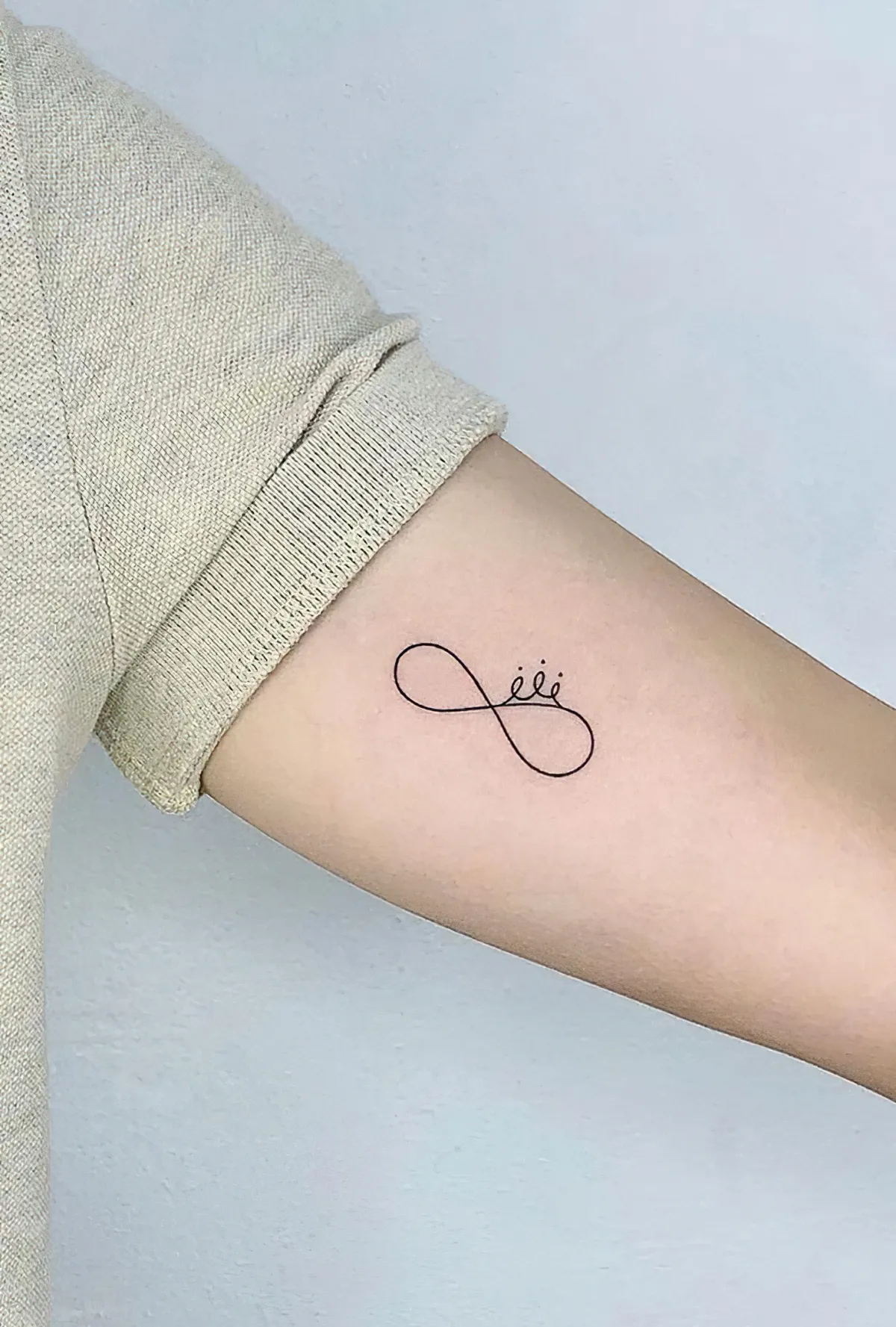 symbol der unendlichkeit am oberarm tattoo