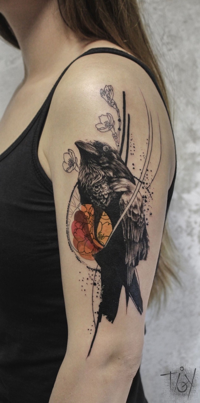 tattoo oberarm frau, vogel als motiv, schwarzer rabe, kleine blüten