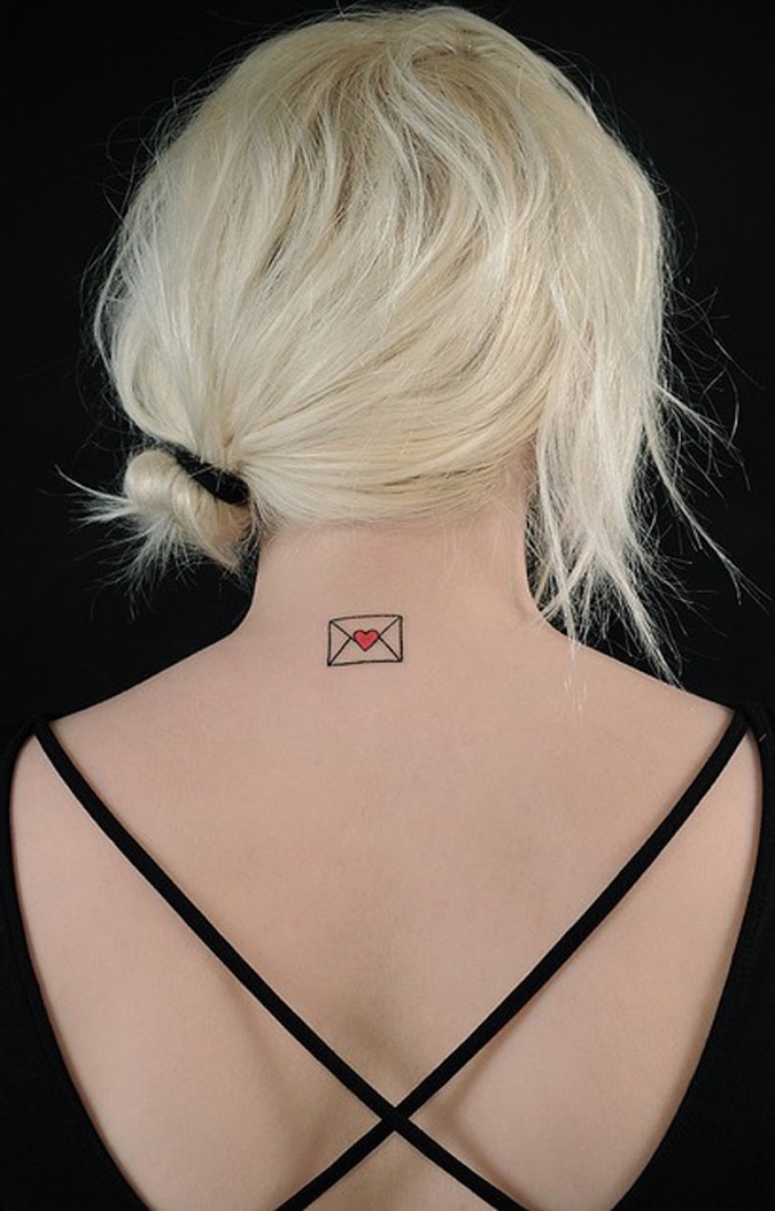 tattoo klein in der form von einer brieftasche, rückentattoo kurze blonde haare, schwarze bluse