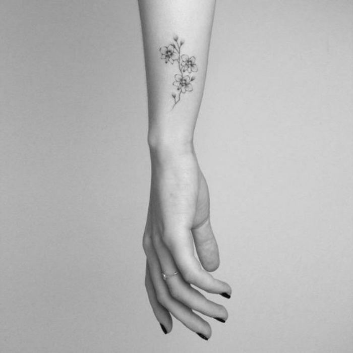 tattoo motive, blumen, arm tattoo, frau, kurze maniküre, ring, schwarz weißes bild