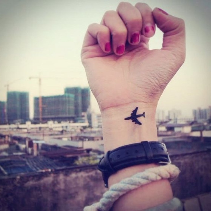 tattoo handgelenk idee für menschen, die gern reisen, ein kleines flugzeug als tattoo am arm gestalten