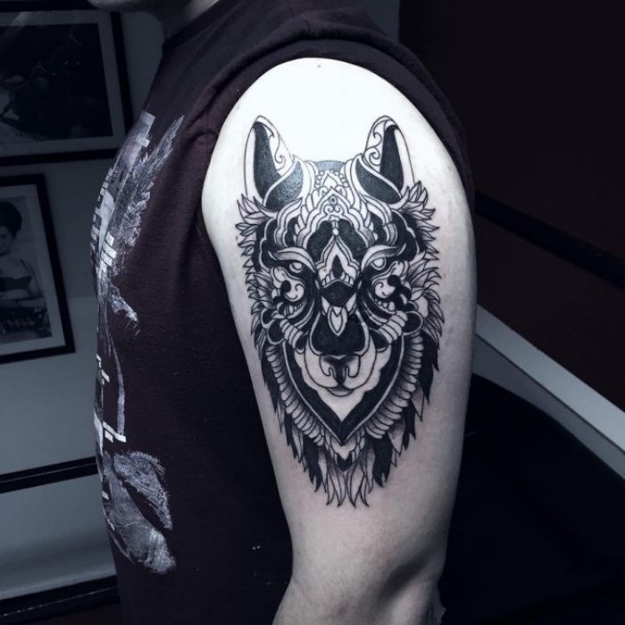 mann mit wolf tattoo am arm, blackwork tribal tätowierung, wolfkopf