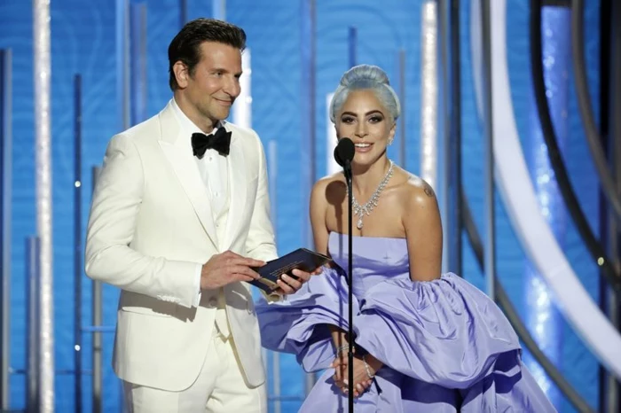 Bradley Cooper und Lady Gaga, schön gekleidet, Lady Gaga mit einem blauen Kleid und Bradley mit weißem Anzug