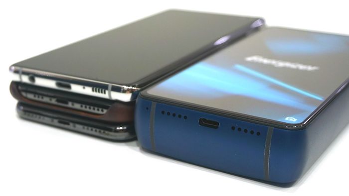 ein großes und dickes smartphone Energizer-P18K-Pop mit einem blauen bildschirm und drei dünne schwarze handys