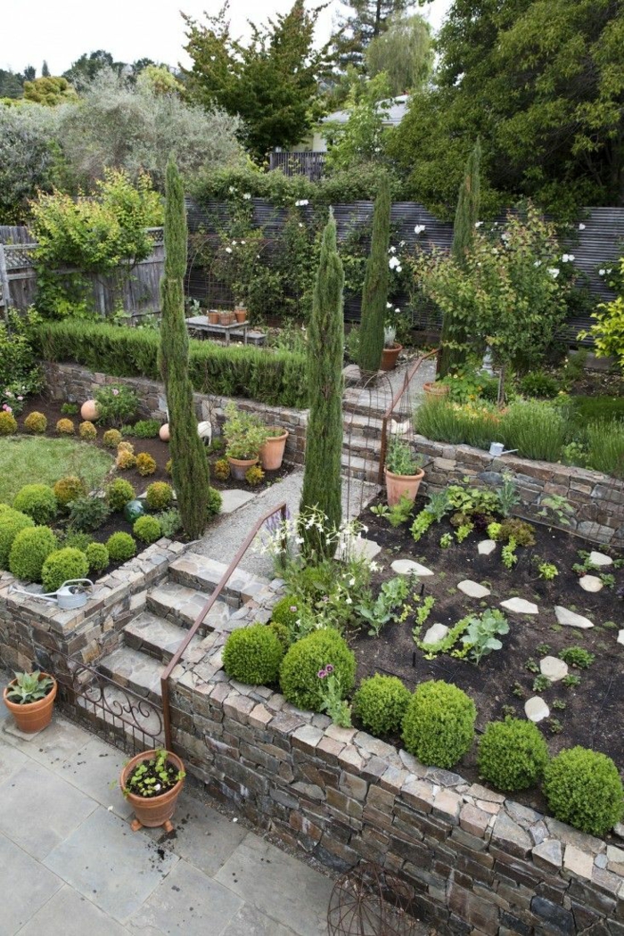 moderne Gartengestaltung, ein bunter Garten, eine Treppe, hohe Ziersträucher, gerundete Hecke