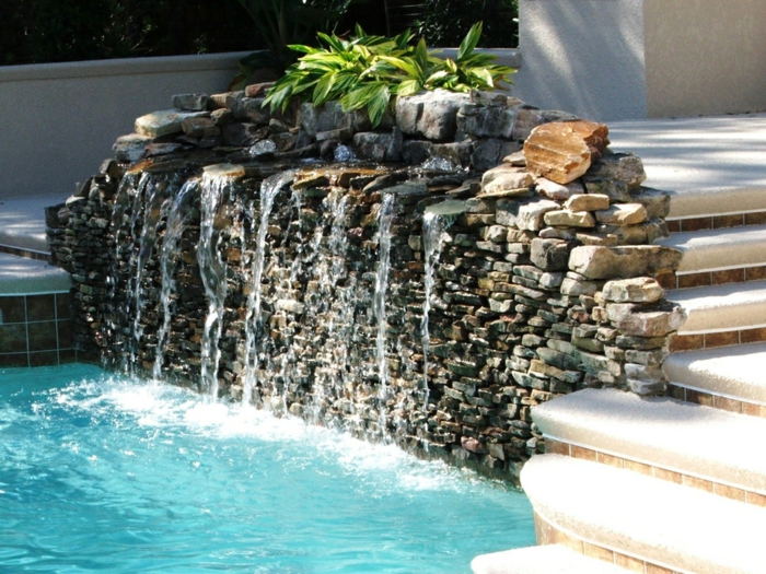 ein Wasserspiel mit kleinen Steinen, ein Teich mit blauem Wasser, Treppen, Garten Ideen