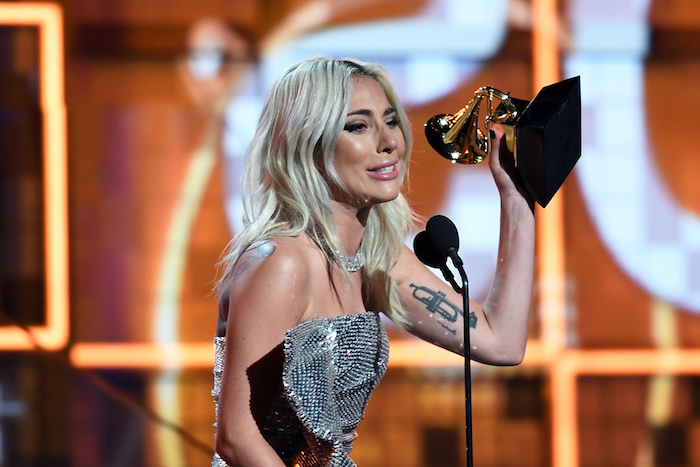 Lady Gaga bei den Grammys 2019, silbernes Kleid mit Pailletten, Saxofon Tattoo am Oberarm 