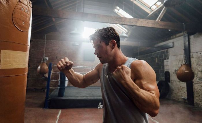 sport treiben,n der schauspieler chris chemsworth, der trainiert, ein junger mann mit einem grauen unterhemd und mit starken händen, centrfit app