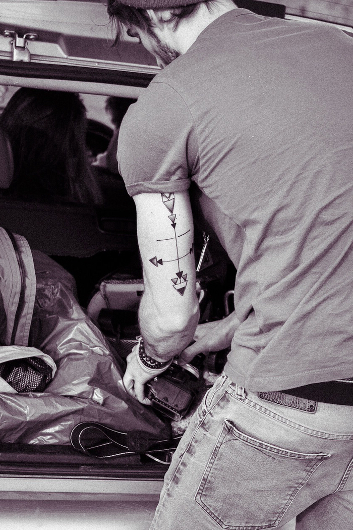 tattoo ideen männer design von einer tätowierung oben an dem arm ideen, mann mit jeans ordnet sein auto