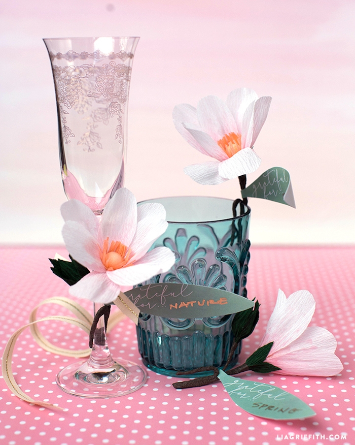 Ideen für selbstgemachte Tischdekoration, kleine weiße Papierblumen an Gläsern befestigen 