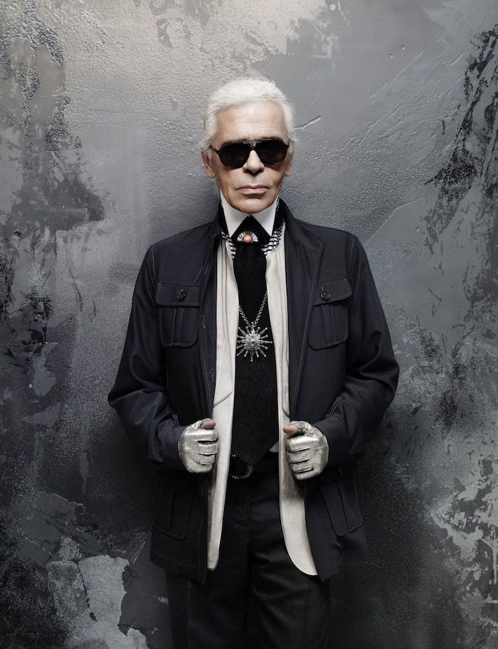 ein alter mann mit einer schwarzen sonnenbrille und schwarzem anzug und schwarzer krawatte und weißem hemd, der designer karl lagerfeld 