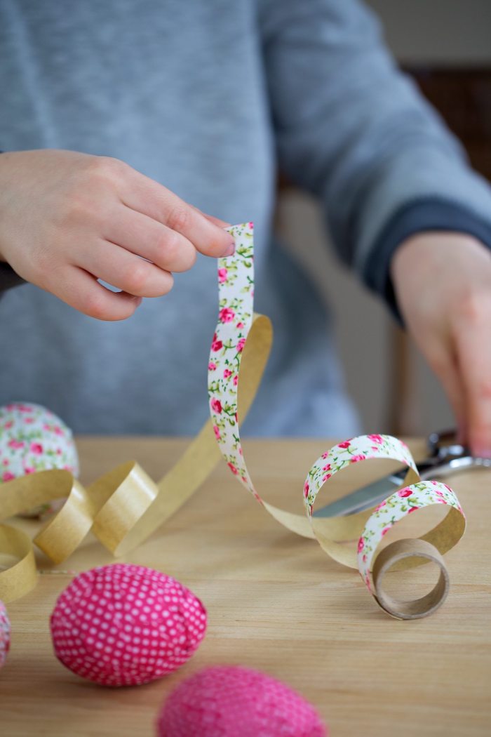 Holzeier mit kleinen Stücken Papier bekleben, Bastelidee zu Ostern für Kinder 