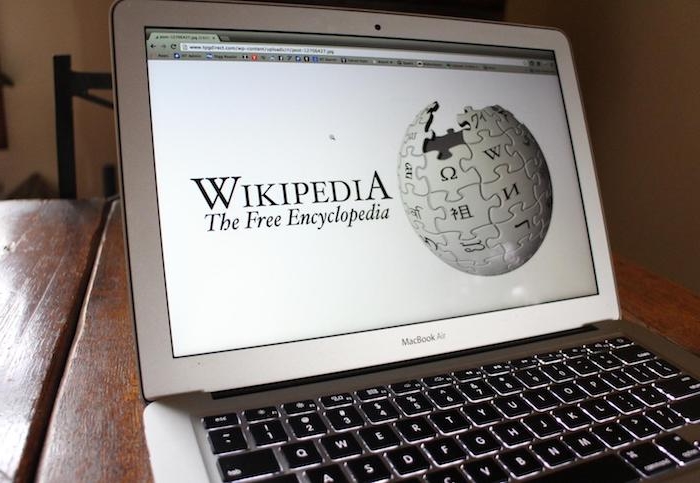 ein laptop mit einem bildschirm mit der startseite von wikipedia mit dem weißen modularen globus, der logo von wikipedia