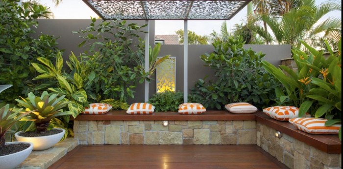 Design Gartenhaus Idee, lange Sitzbank mit rechtem Eck und viele flauschige Sitzkissen, Pflanzen, Ort zum Treffen, Sauna im Garten