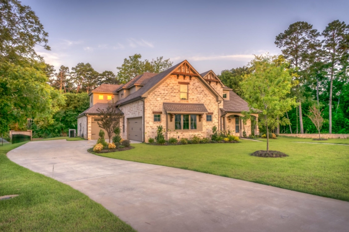 ein kleines Traumhaus mit Garten, ein grüner Rasen, leuchtende Fenster, Hausfinanzierung