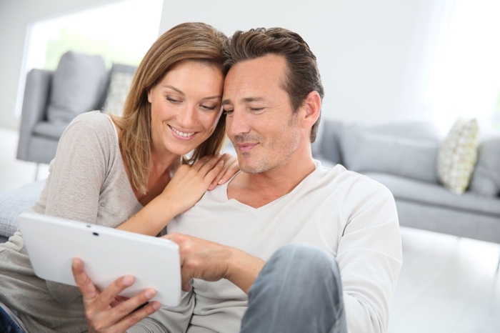 ein Mann und eine Frau sehen Tablet, suchen Sie nach der Traumwohnung, Hausfinanzierung
