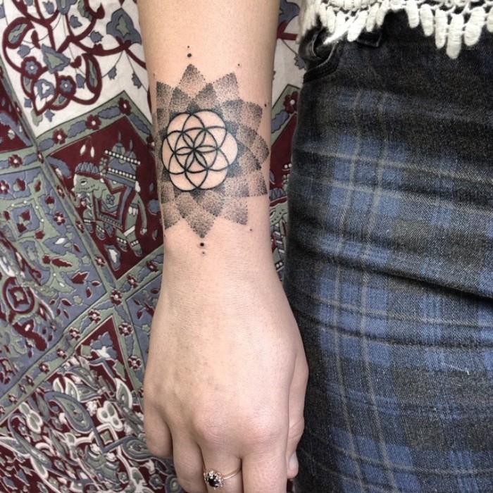 blume des lebens tattoo, eine schöne tattooidee auf dem unterarm, ring am mittelfinger
