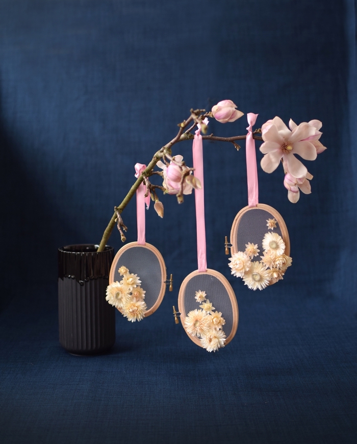 osterdeko selber basteln, selbstgemachte dekorationen aus stickrahmen, papierblumen und rosa schleife