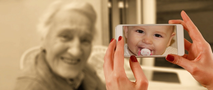 eine Frau nimmt Foto von Großmutter auf, auf dem Display ist ein Bild von Baby, hübsche Bilder