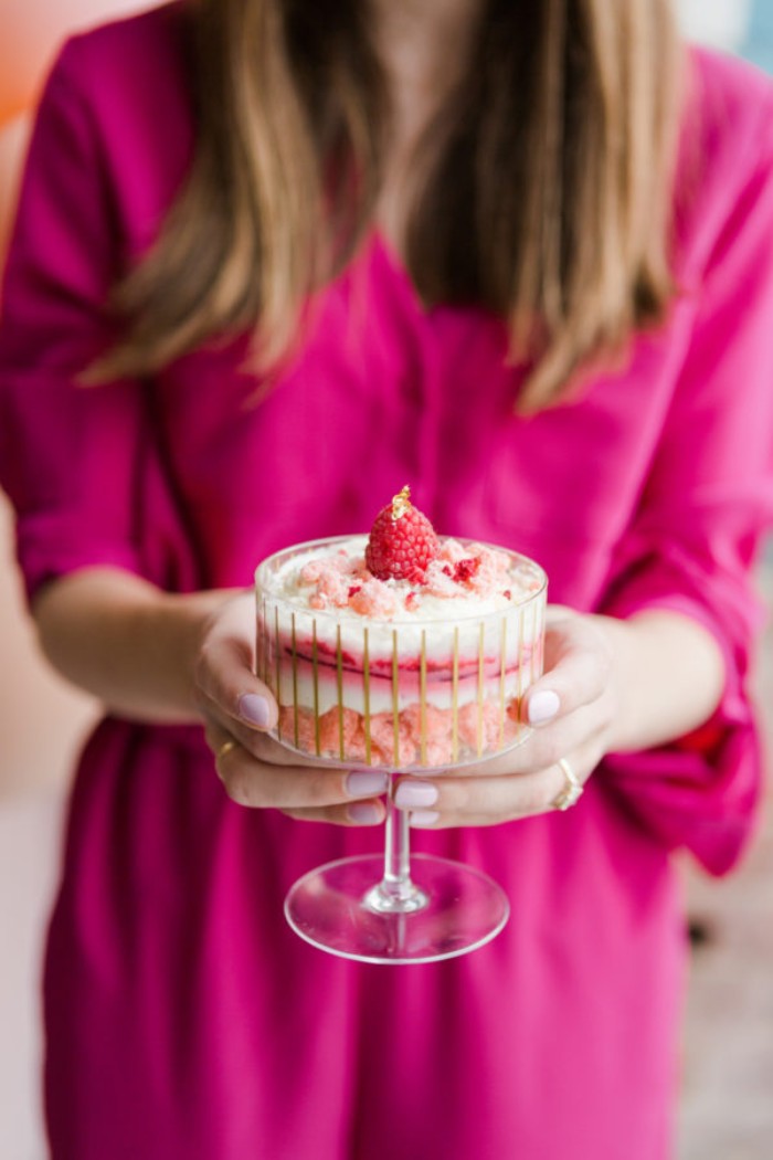 erdbeer joghurt torte, eine frau hält kleine glas schüssel mit dem kuchen, party rezepte für kuchen
