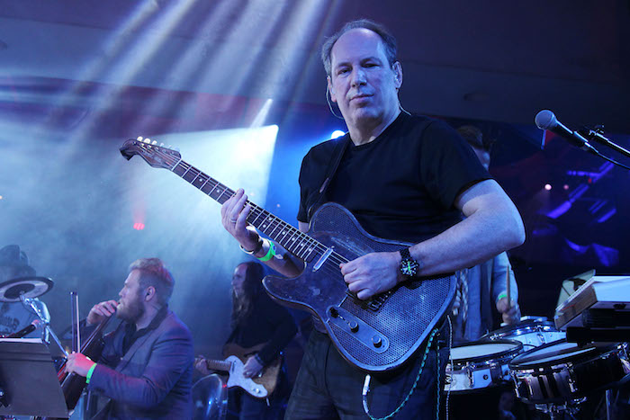 der deutsche komponist hans zimmer, ein alter mann mit schwarzen t-shirt, einer schwarzen gitarre und einer schwarzen armbanduhr