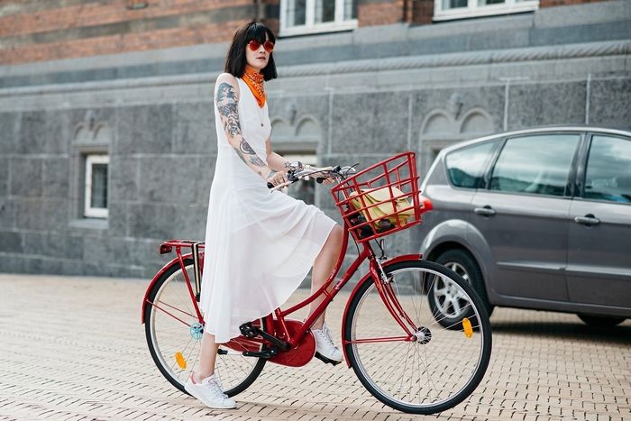 bob frisuren kurz, eine frau auf der straße mit ihren fahrrad, rotes rad, weißes kleid, schwarzes haar
