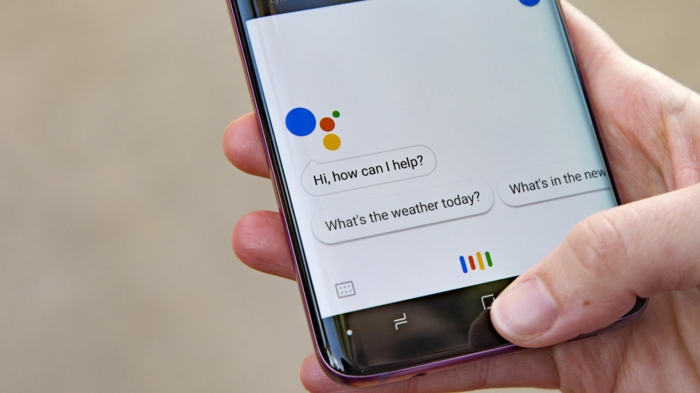 ein Mann trägt Smartphone mit Google Assistant, Google Assistant bietet die oft gestellten Fragen