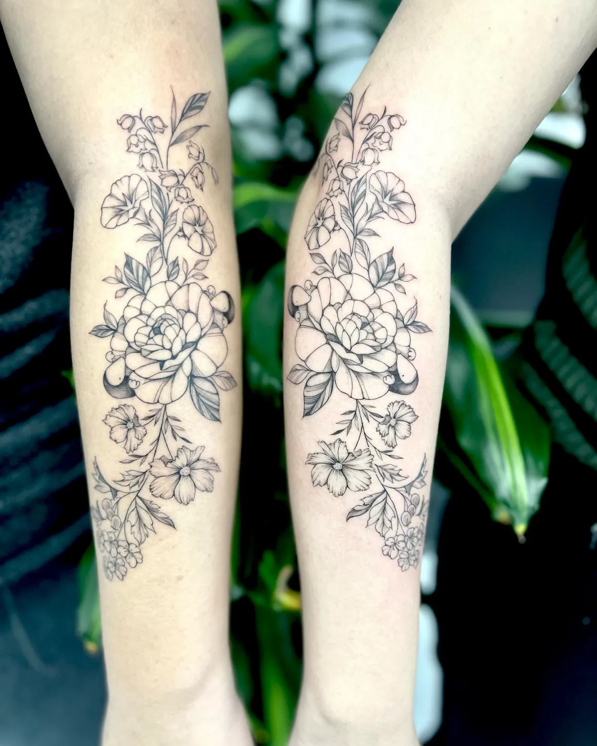 gleiche florale black work tattoos für zwillingsschwestern