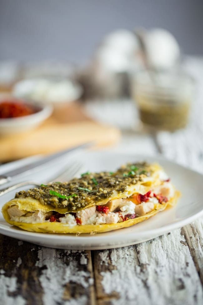 ideen für brunch, omelette mit schinken, paprika, ziegenkäse garniert mit grüßem soße
