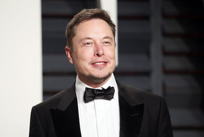 Elon Musk mit elegantem Anzug, schwarzer Sakko, weißes Hemd, schwarze Fliege