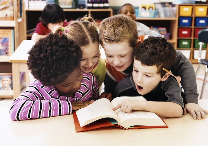 Welttag des Buches feiern am 23. April, Kinder fürs Lesen begeistern, vier Kinder lesen zusammen