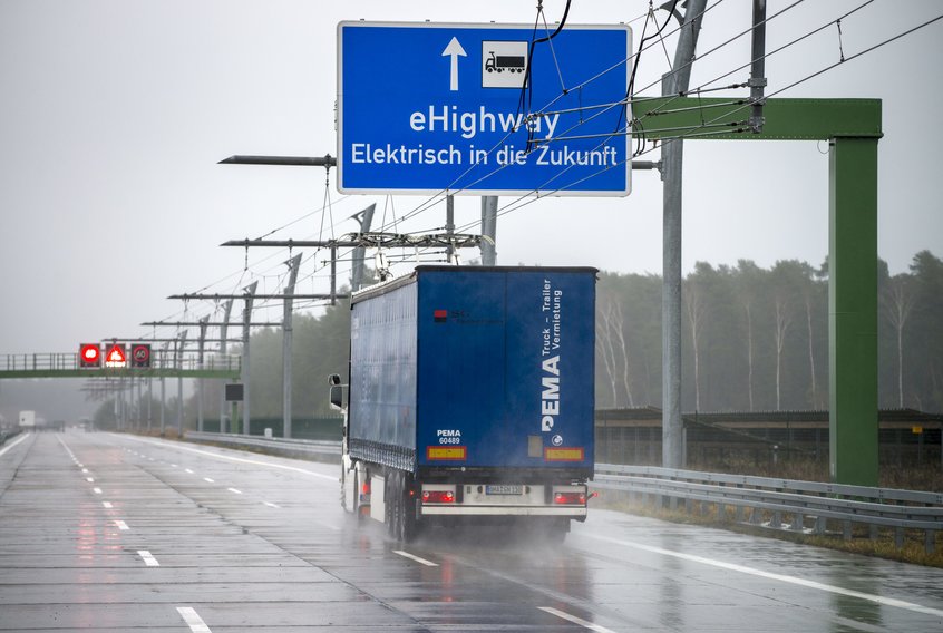 ein blauer Lastwagen unter blauer Tabelle im Regen, E-Highway in Deutschland