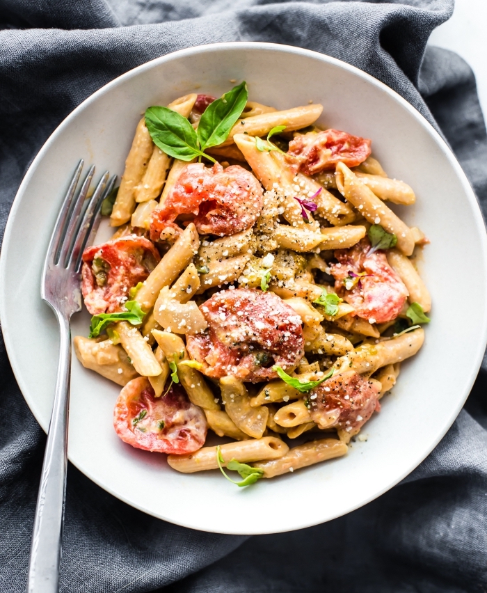 glutenfrei kochen, pasta mit romaten und basilikum, veganer mittagessen, großer weißer teller, gabel