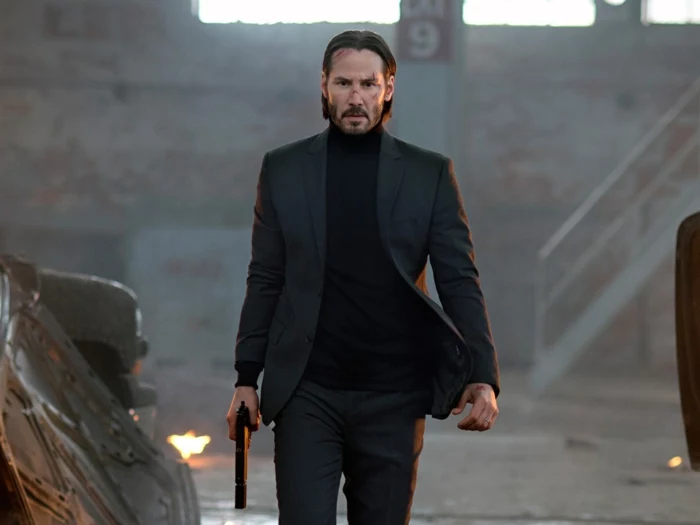 Keanu Reeves als John Wick, der Schauspieler in einem schwarzen Anzug mit Pistole in der Hand