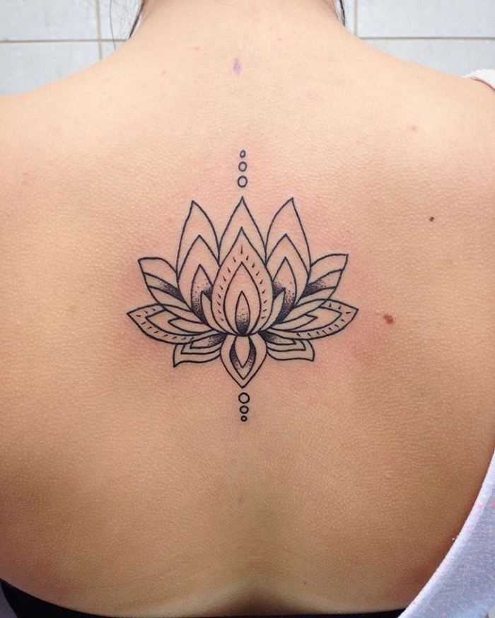 frau mit blackwork tattoo am rücken, buddhismus symbole ideen, tätowierung am rücken, lotus