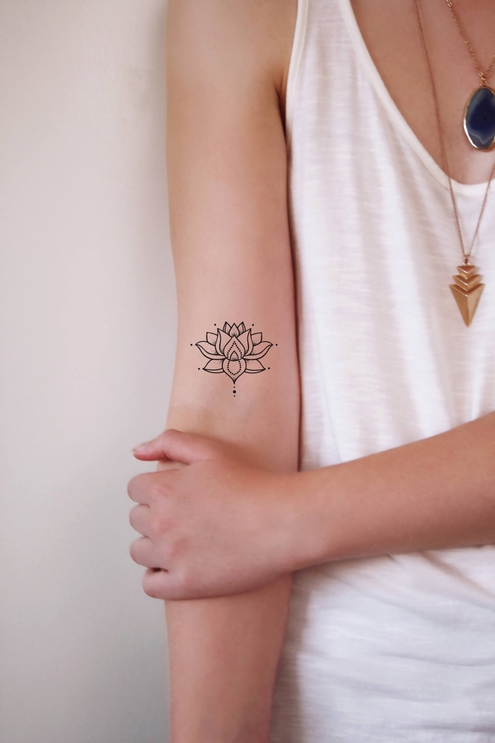 buddhismis symbole, klene tattoo motive für frauen, kleine lotusblumme am oberarm