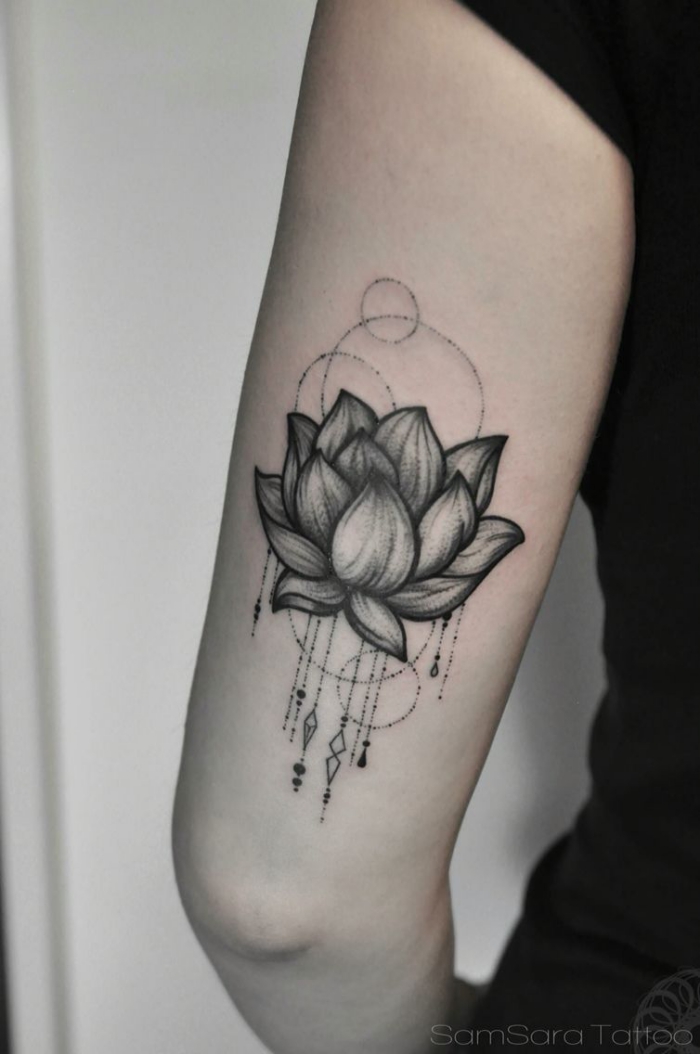 lotusbl+te am oberarm, buddhismus symbole tattoo, schwarz graue tätowierung am oberarm