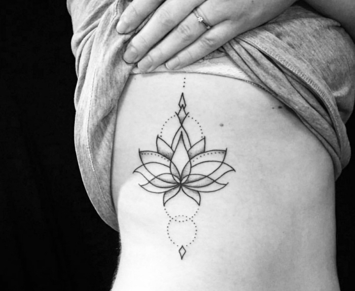 buddhistische symbole tattoo blackwork, schwarz graue tätowierung an der körperseite, lotus