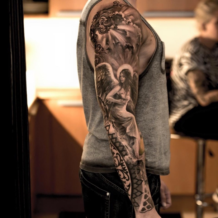 engel tattoo arm, mann mit großer realitischer tätowierung am arm, sleeve tattoo, frau mit flügeln