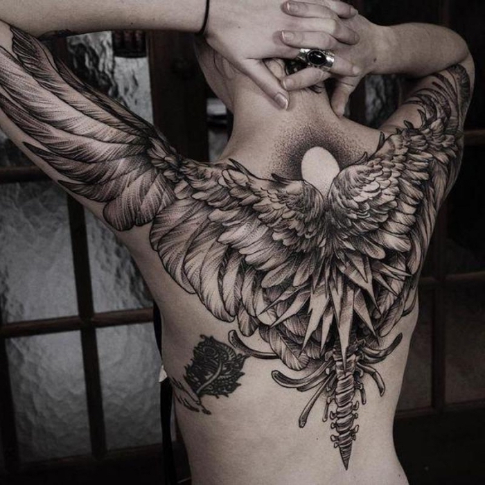 engel tattoo, frau mit großer blackwork tätowierung am rücken, ralitische engelsflügel 