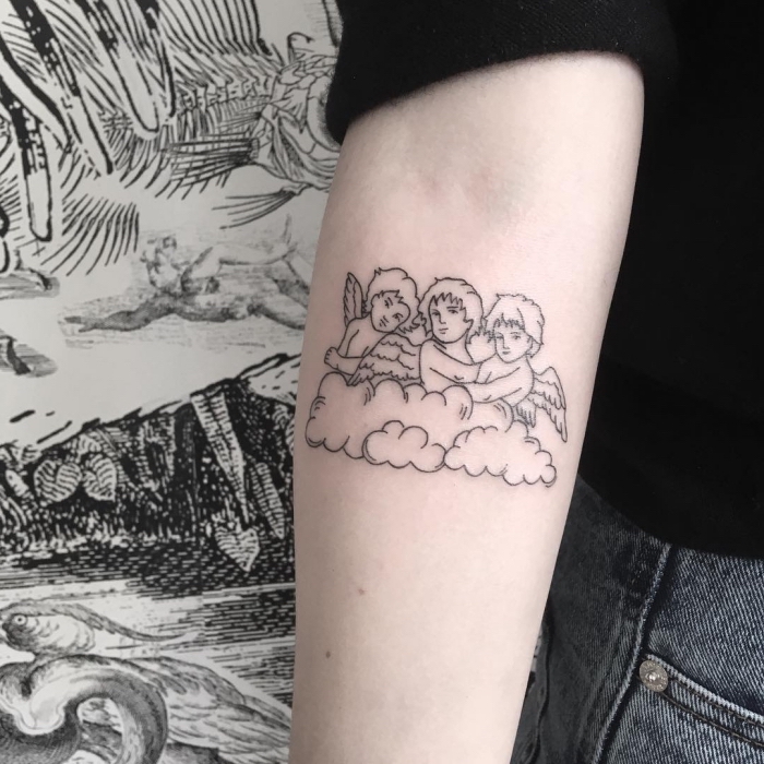 engelsflügel tattoo klein, frau mit tätowierung am unterarm, drei kleine kinder mit flügeln, wolke