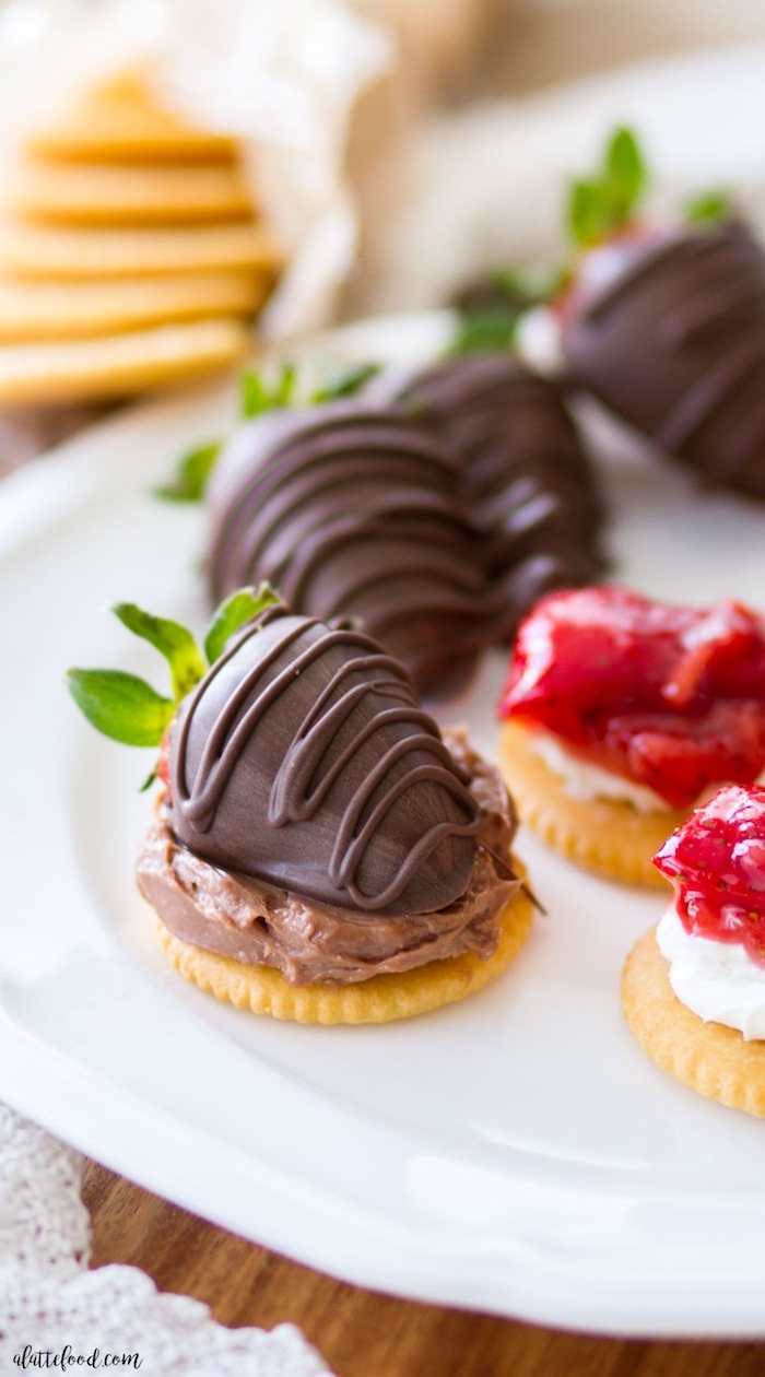 Kleine Snacks für Party, Kräcker mit Schokoladencreme und frischen Erdbeeren 