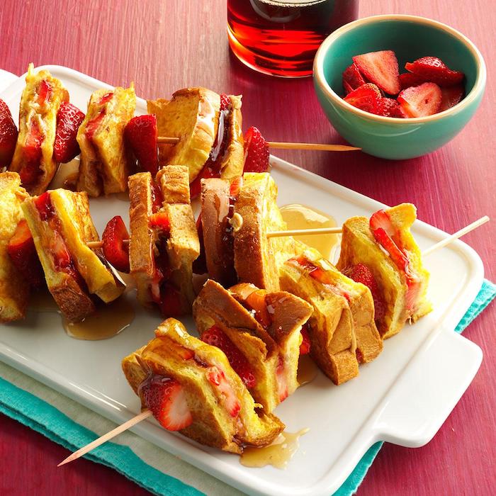 Fingerfood Spieße, French Toasts mit frischen Erdbeeren und Honig, leckeres Essen für Party 