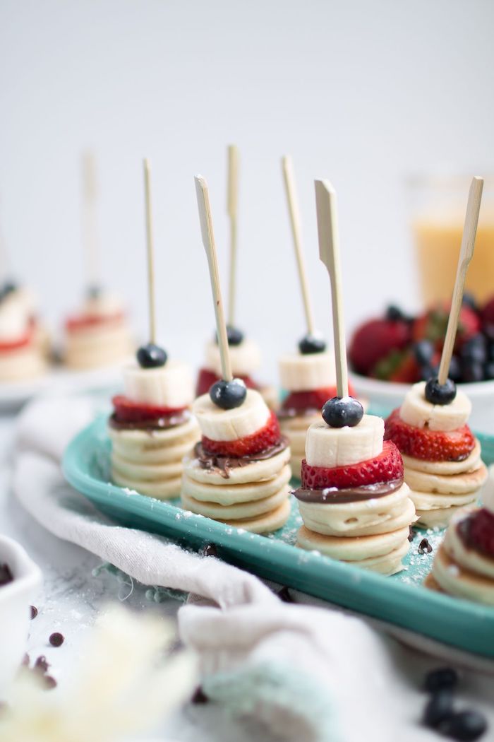 Kleine Party Häppchen, Mini Pfannkuchen mit Schokolade Erdbeeren Bananenscheiben und Blaubeeren 