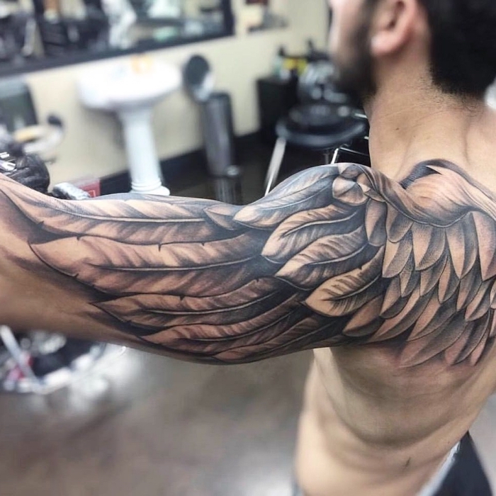 flügel tattoo arm, mann mit großer realistischer tätowierung arm schulter und oberarm, engelsflügel