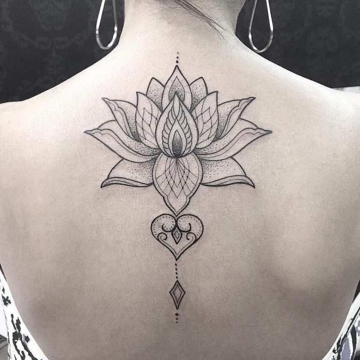 frau mit lotus tattoo am rücken, tätowierung mit geometrischen motiven, große blume, lotusblume